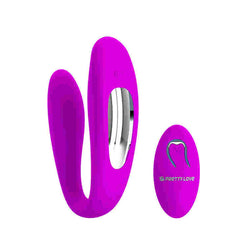 Woman's hand holding the PRETTY LOVE LETITIA vibrator next to a bed with romantic lighting