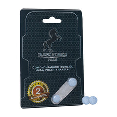 Close up of a hand holding a blister pack of black pills with the label Pastillas Black Power para Vitalidad Masculina, promoting male wellness and energy