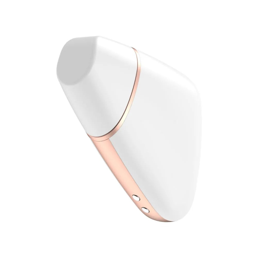 Satisfyer Love Triangle placed on a floral-patterned fabric